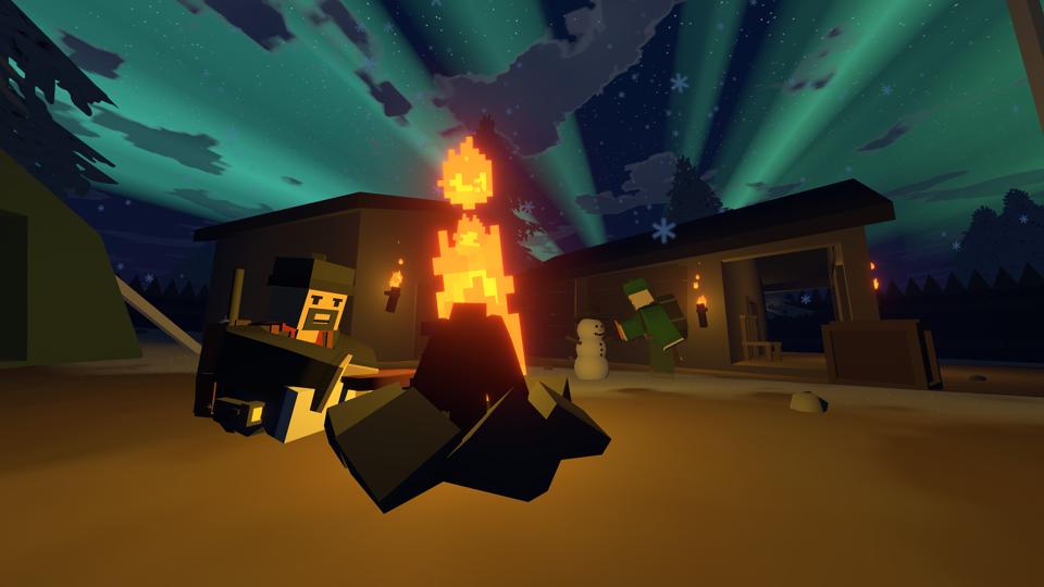 A player warms themselves by a campfire while another builds a snowman.